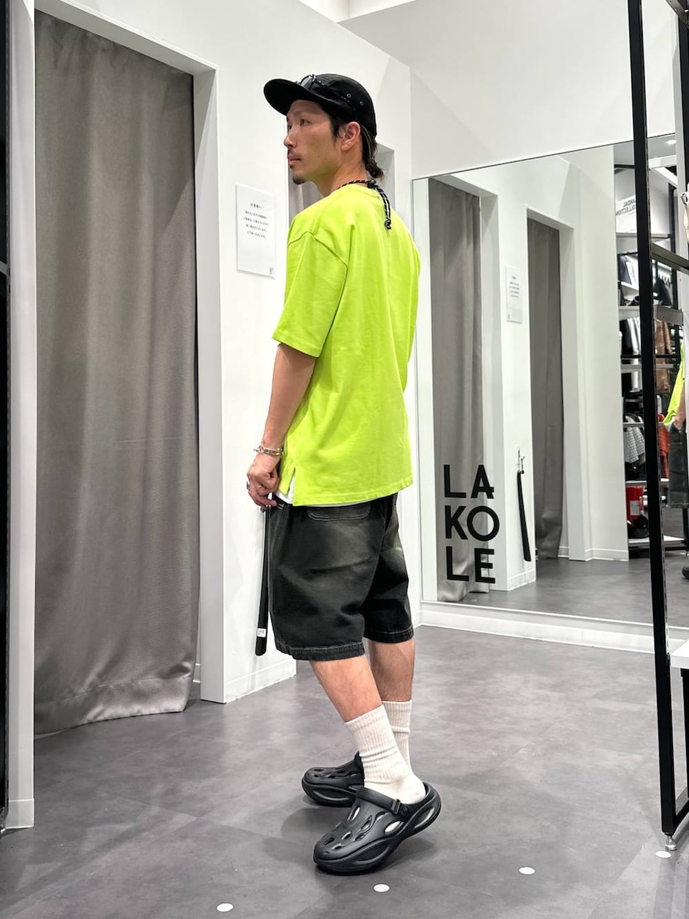 ブラック系のデニムパンツ、ホワイト系のTシャツ/カットソー、ブラック系のサンダルを着用したメンズの春コーディネートの4枚目の写真