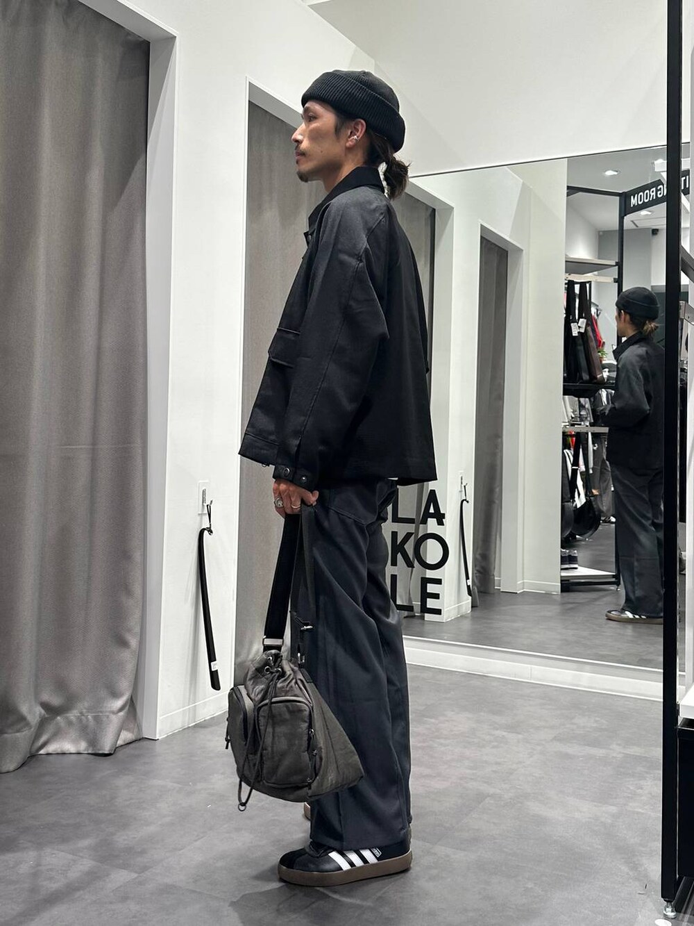 グレー系のその他パンツ、グレー系のショルダーバッグ、ブラック系のスニーカーを着用したメンズの秋コーディネートの4枚目の写真