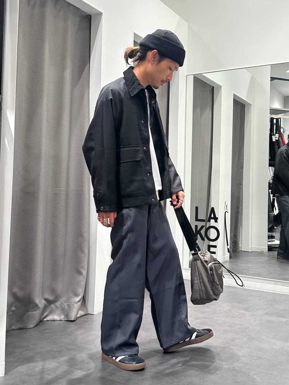 グレー系のその他パンツ、グレー系のショルダーバッグ、ブラック系のスニーカーを着用したメンズの秋コーディネートの2枚目の写真