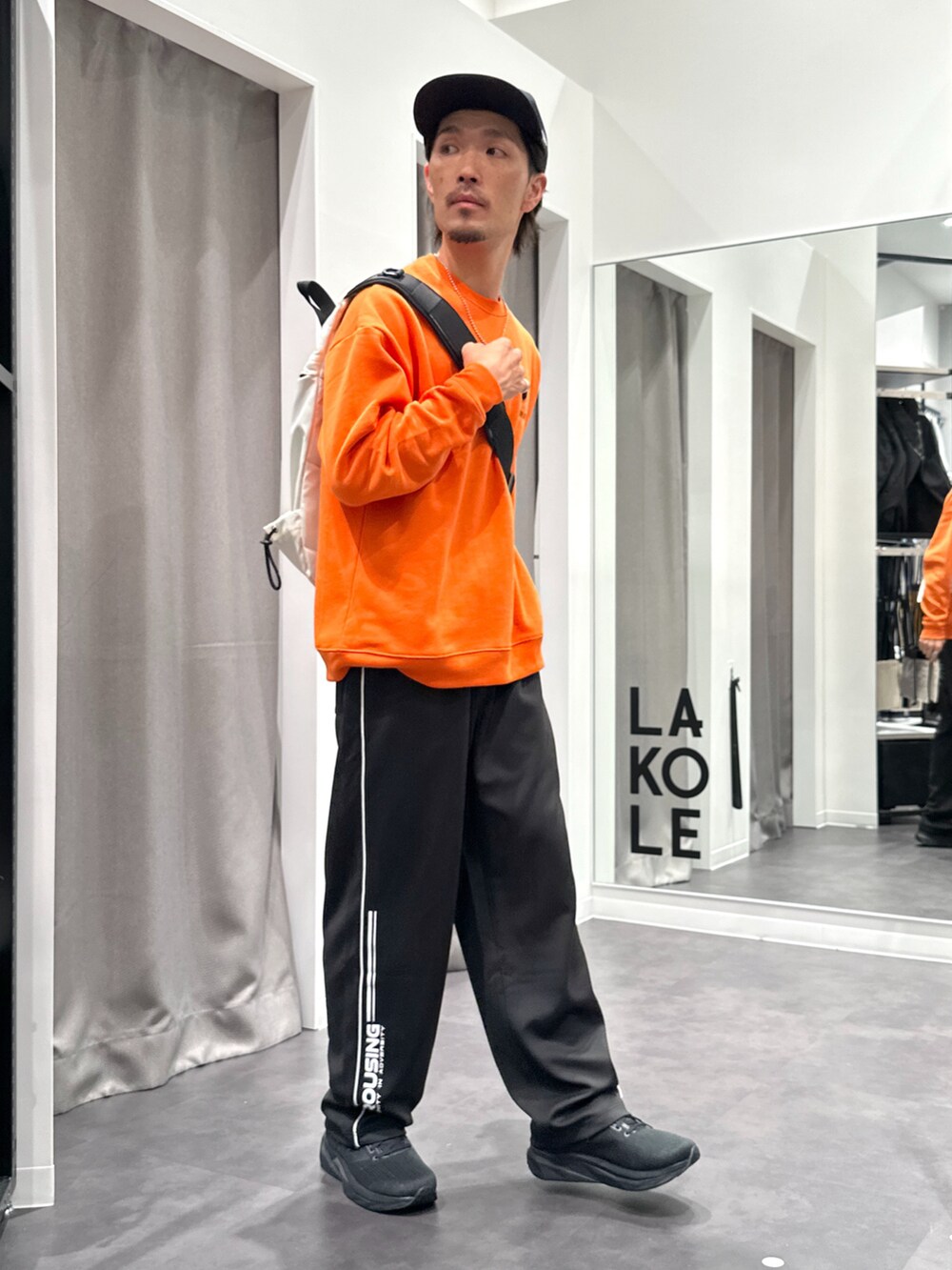 ブラック系のその他パンツ、ブラック系のスニーカー、オレンジ系のスウェットを着用したメンズの秋コーディネートの2枚目の写真