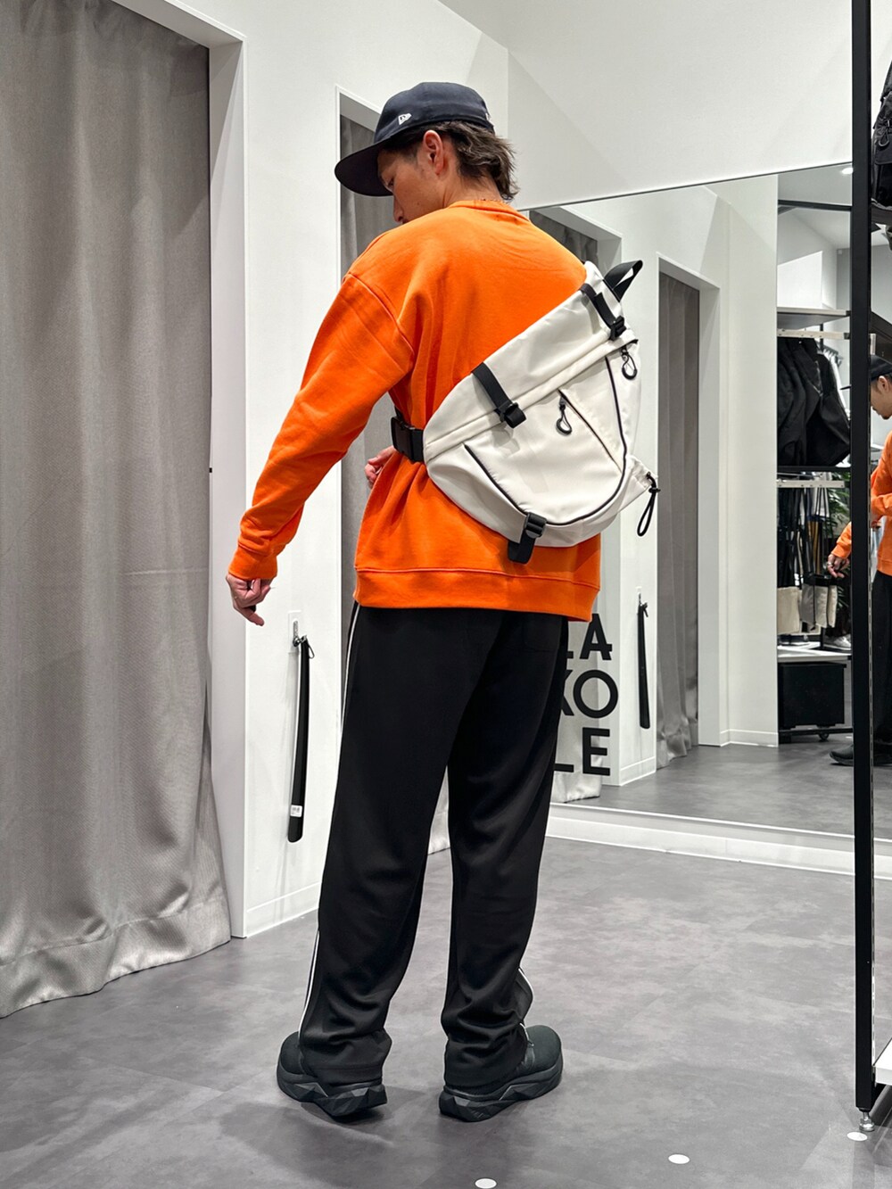 ブラック系のその他パンツ、ブラック系のスニーカー、オレンジ系のスウェットを着用したメンズの秋コーディネートの5枚目の写真