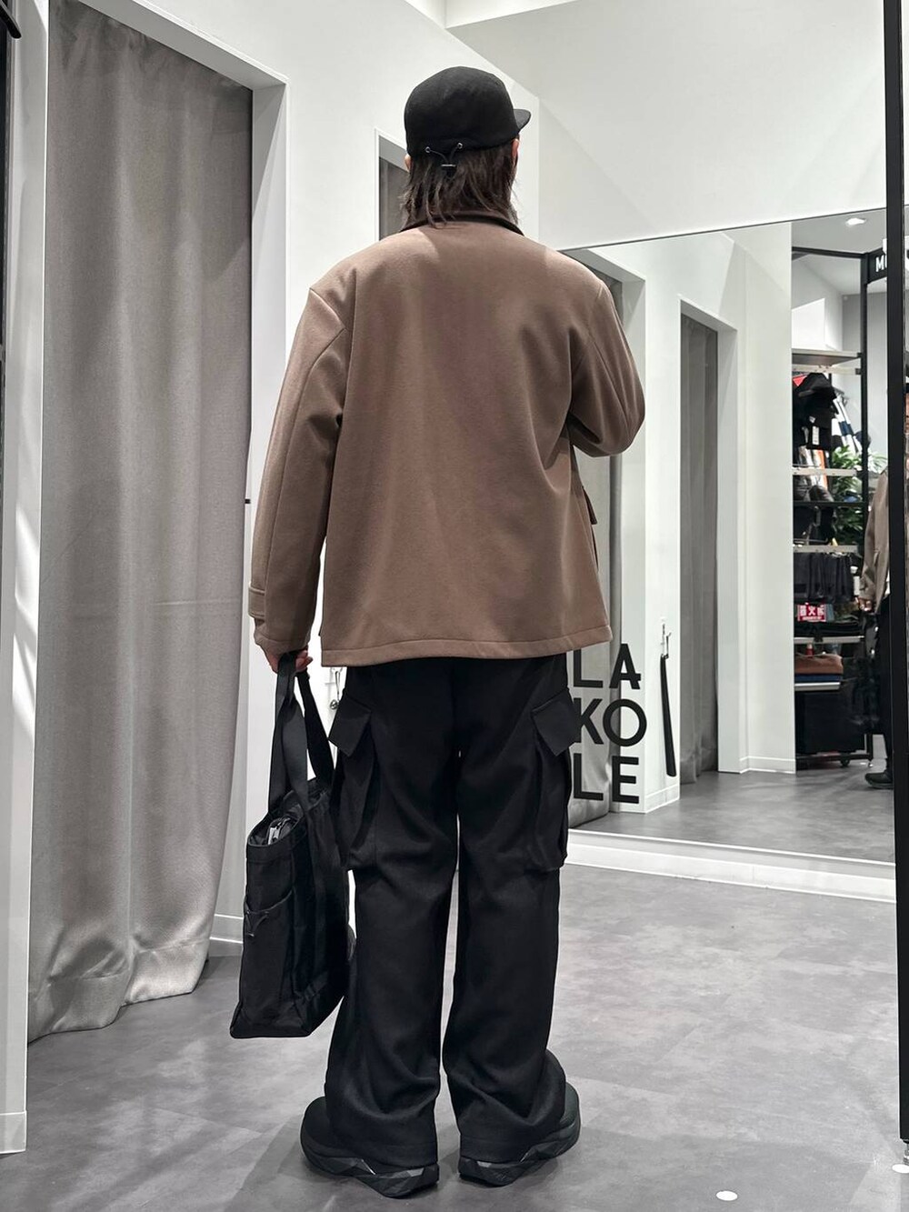 ブラック系のスニーカー、ベージュ系のブルゾン、ブラック系のトートバッグを着用したメンズの冬コーディネートの4枚目の写真