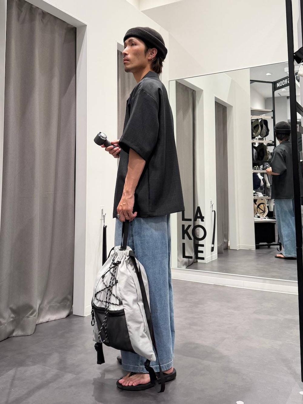 ブラック系のサンダル、ホワイト系のTシャツ/カットソー、ブルー系のデニムパンツを着用したメンズの春コーディネートの4枚目の写真