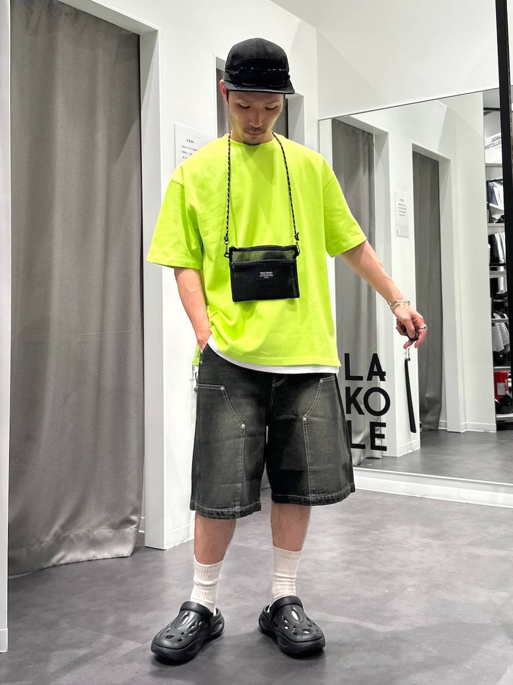 ブラック系のデニムパンツ、ホワイト系のTシャツ/カットソー、ブラック系のサンダルを着用したメンズの春コーディネートの3枚目の写真