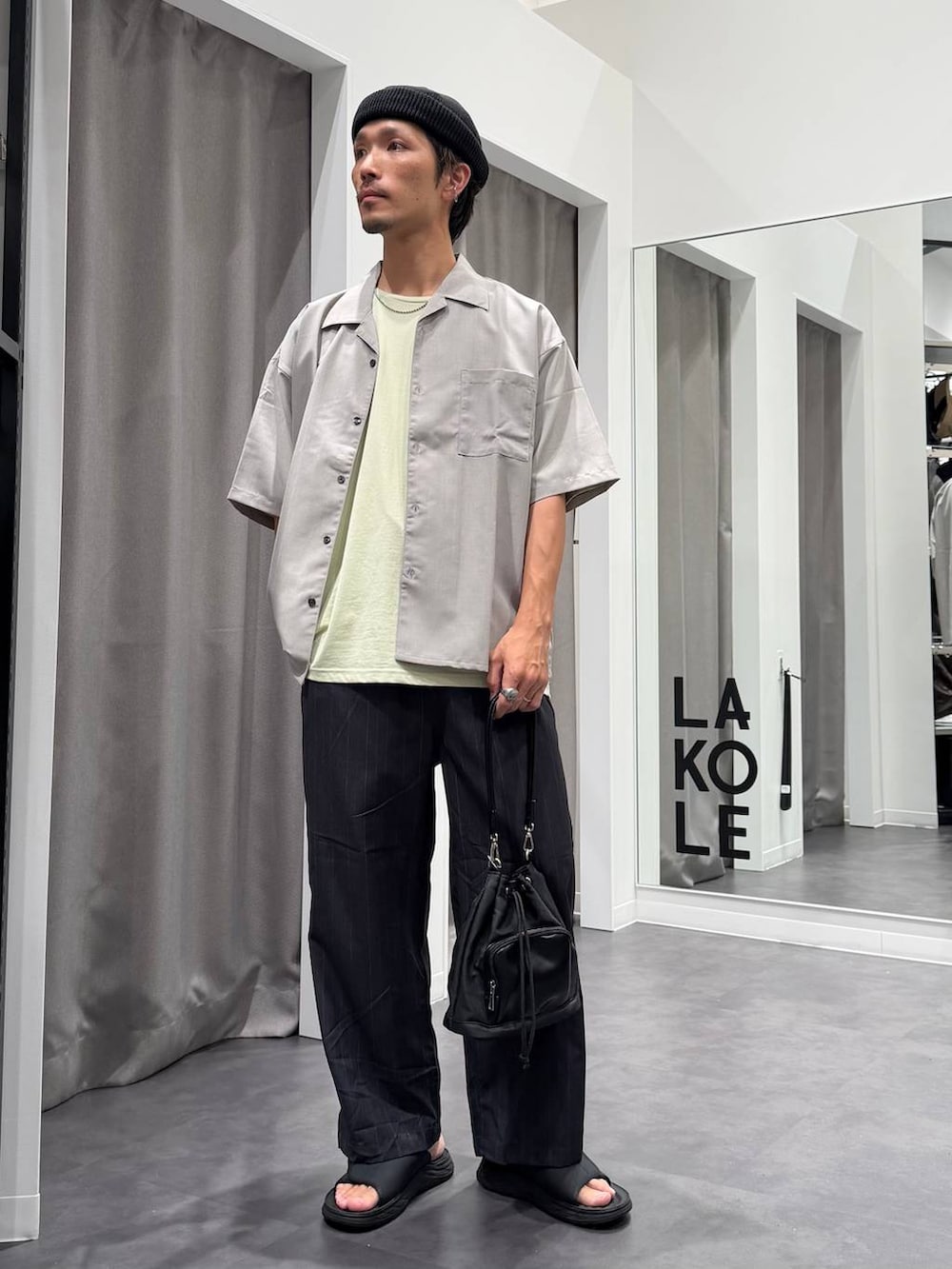 グリーン系のTシャツ/カットソー、ブラック系のサンダル、グレー系のシャツ/ブラウスを着用したメンズの夏コーディネートの2枚目の写真