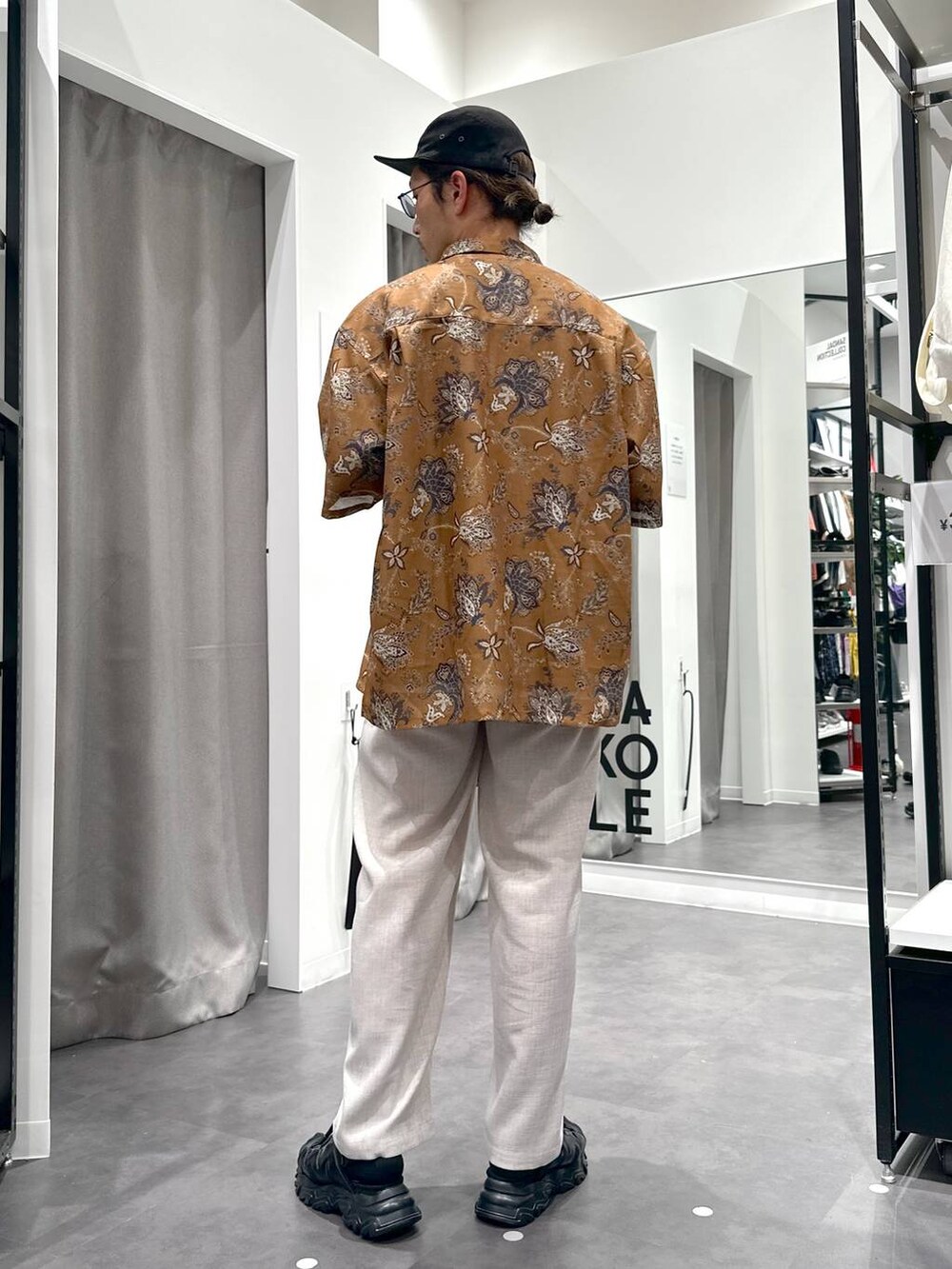 ブラック系のサンダル、ホワイト系のその他パンツ、グリーン系のショルダーバッグを着用したメンズの春コーディネートの4枚目の写真