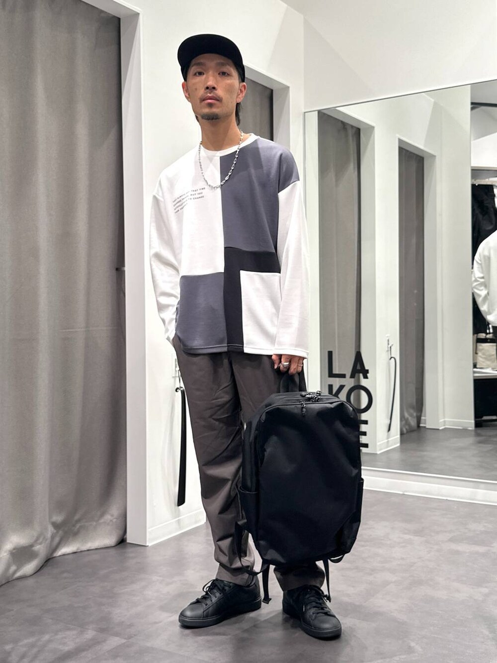 グレー系のその他パンツ、ブラック系のTシャツ/カットソー、ブラック系のバックパック/リュックを着用したメンズの秋コーディネートの2枚目の写真