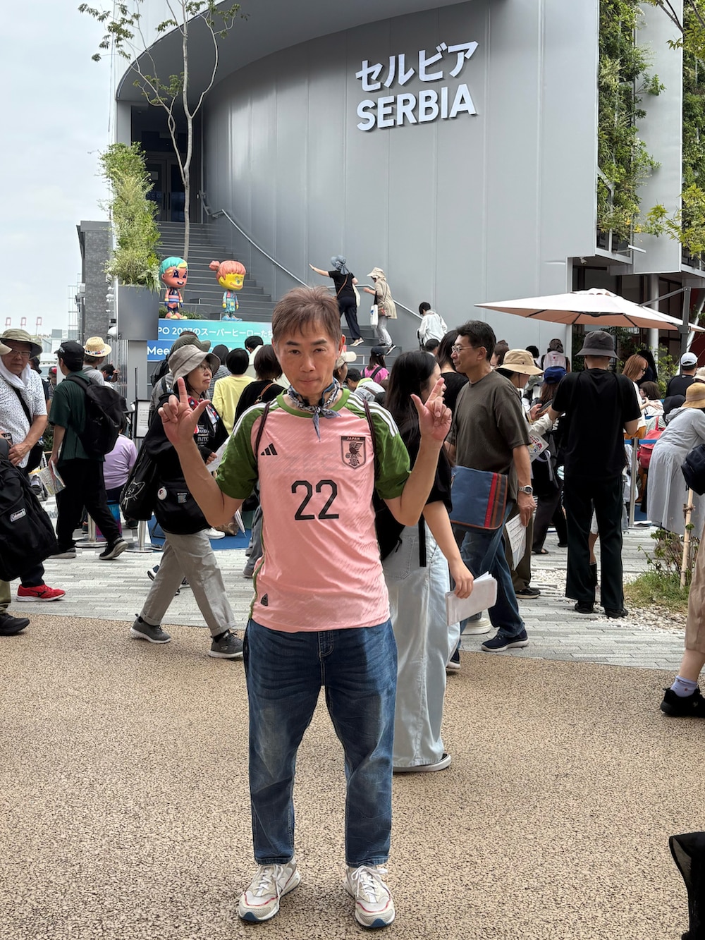 ホワイト系のスニーカー、ピンク系のTシャツ/カットソー、ブルー系のデニムパンツを着用したメンズの秋コーディネートの5枚目の写真