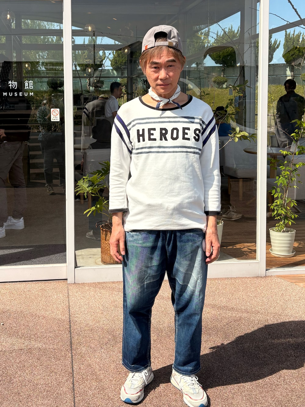 ホワイト系のスニーカー、ホワイト系のTシャツ/カットソー、ブルー系のデニムパンツを着用したメンズの春コーディネートの2枚目の写真