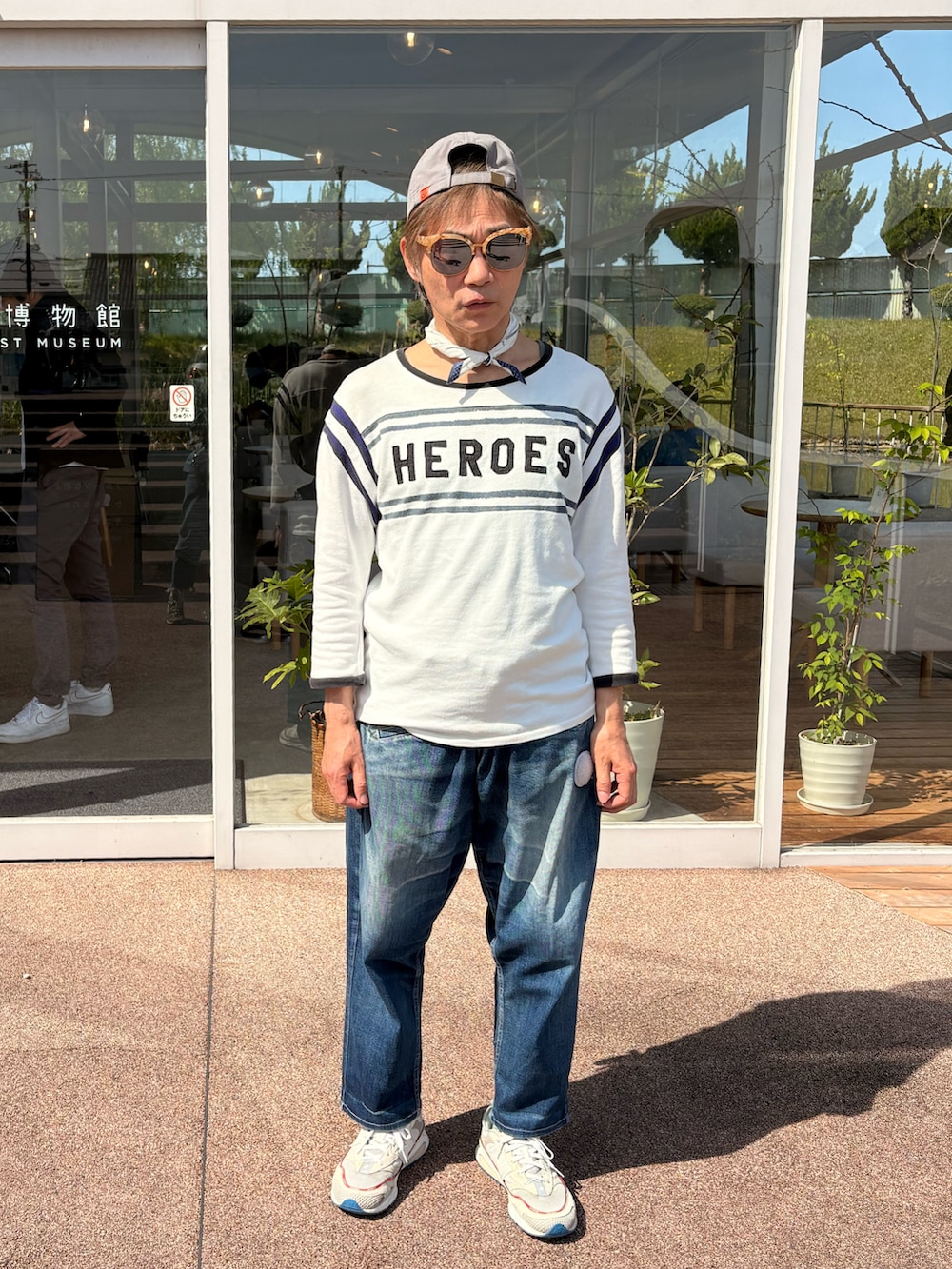 ホワイト系のスニーカー、ホワイト系のTシャツ/カットソー、ブルー系のデニムパンツを着用したメンズの春コーディネートの3枚目の写真