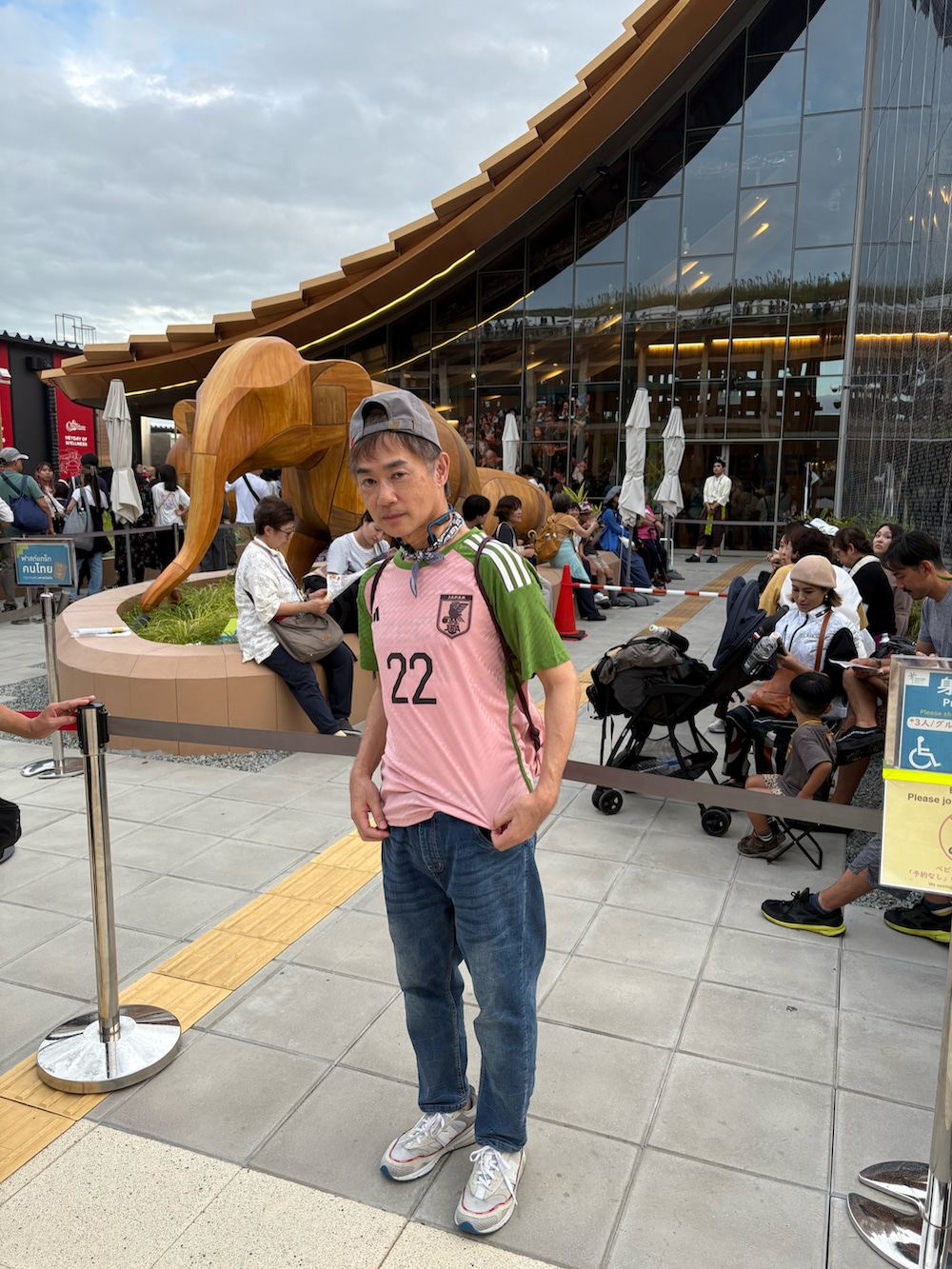 ホワイト系のスニーカー、ピンク系のTシャツ/カットソー、ブルー系のデニムパンツを着用したメンズの秋コーディネートの2枚目の写真