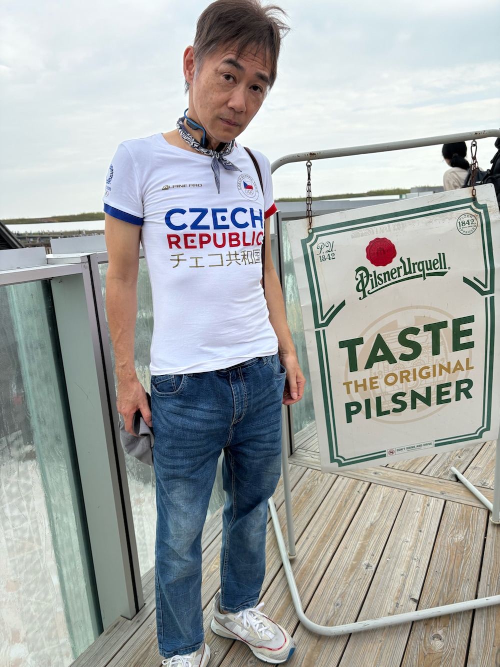 ホワイト系のスニーカー、ホワイト系のTシャツ/カットソー、ブルー系のデニムパンツを着用したメンズの秋コーディネートの5枚目の写真