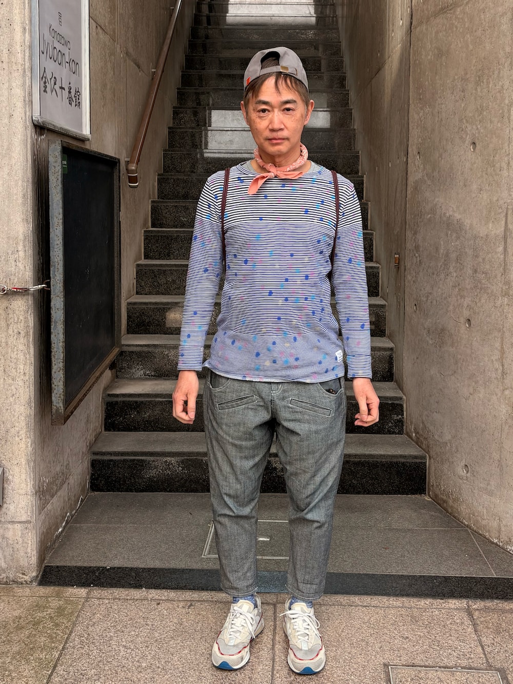 ホワイト系のスニーカー、ブルー系のTシャツ/カットソー、グレー系のデニムパンツを着用したメンズの春コーディネートの2枚目の写真