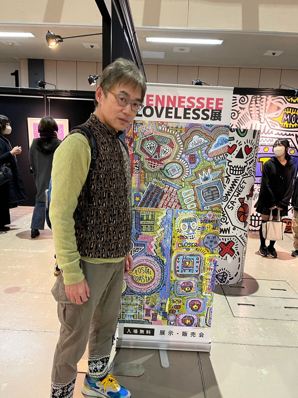 グレー系のスニーカー、ブラウン系のベスト、グリーン系のニット/セーターを着用したメンズの冬コーディネートの3枚目の写真