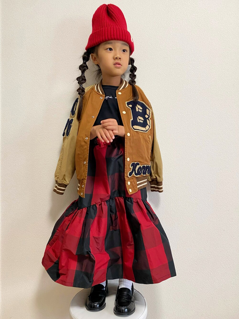 ブラウン系のスタジャン、ブラック系のTシャツ/カットソー、レッド系のスカートを着用したキッズの秋コーディネートの3枚目の写真