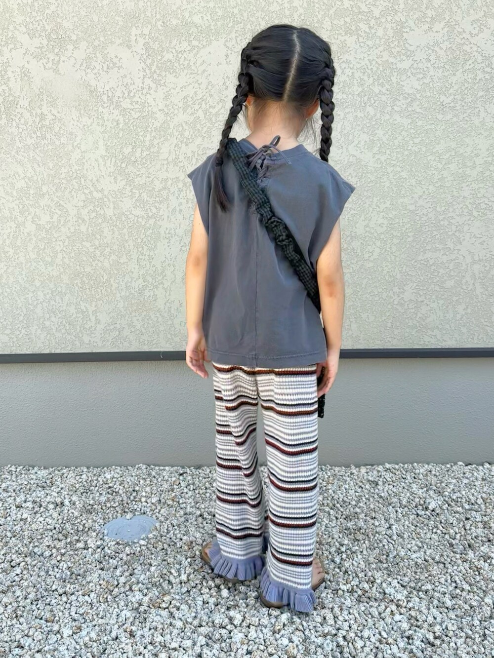 グレー系のTシャツ/カットソー、パープル系のパンツ、ブラック系のショルダーバッグを着用したキッズの夏コーディネートの3枚目の写真