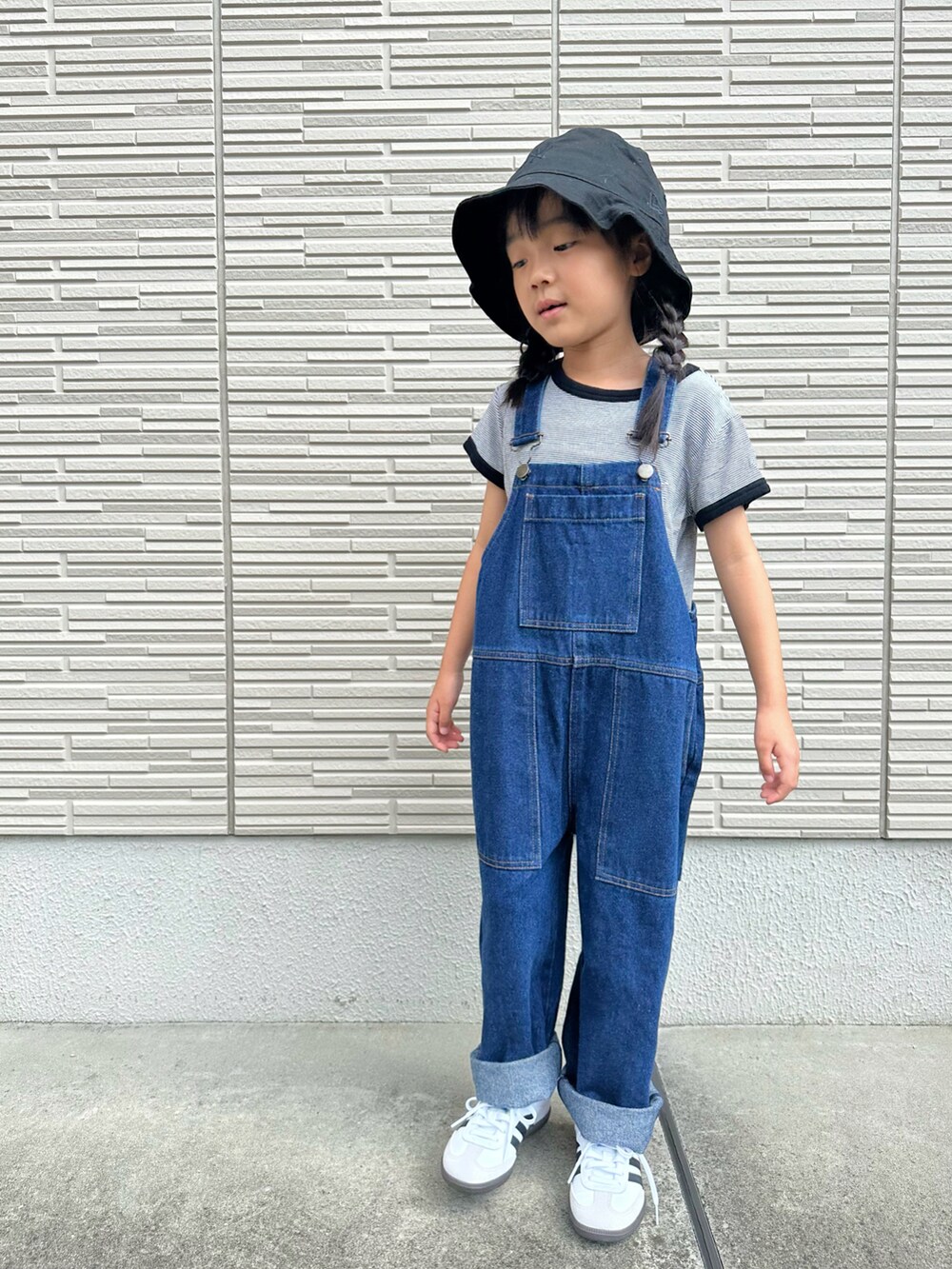ブラック系のTシャツ/カットソー、ブルー系のサロペット/オーバーオール、ホワイト系のスニーカーを着用したキッズの秋コーディネートの3枚目の写真