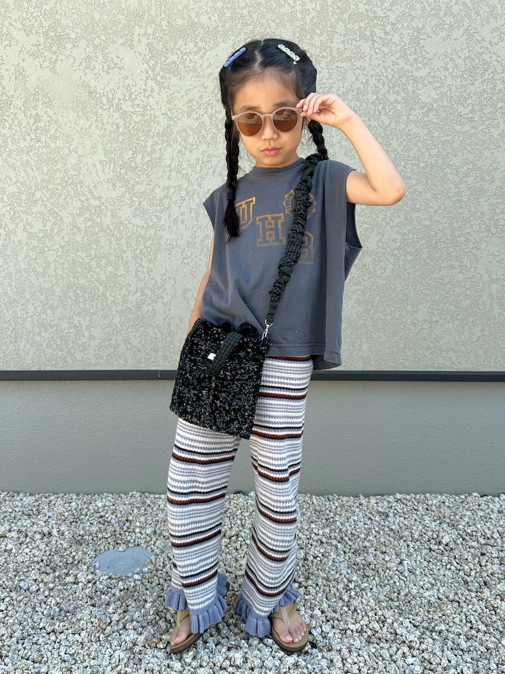 グレー系のTシャツ/カットソー、パープル系のパンツ、ブラック系のショルダーバッグを着用したキッズの夏コーディネートの4枚目の写真