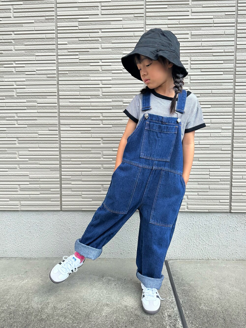 ブラック系のTシャツ/カットソー、ブルー系のサロペット/オーバーオール、ホワイト系のスニーカーを着用したキッズの秋コーディネートの2枚目の写真