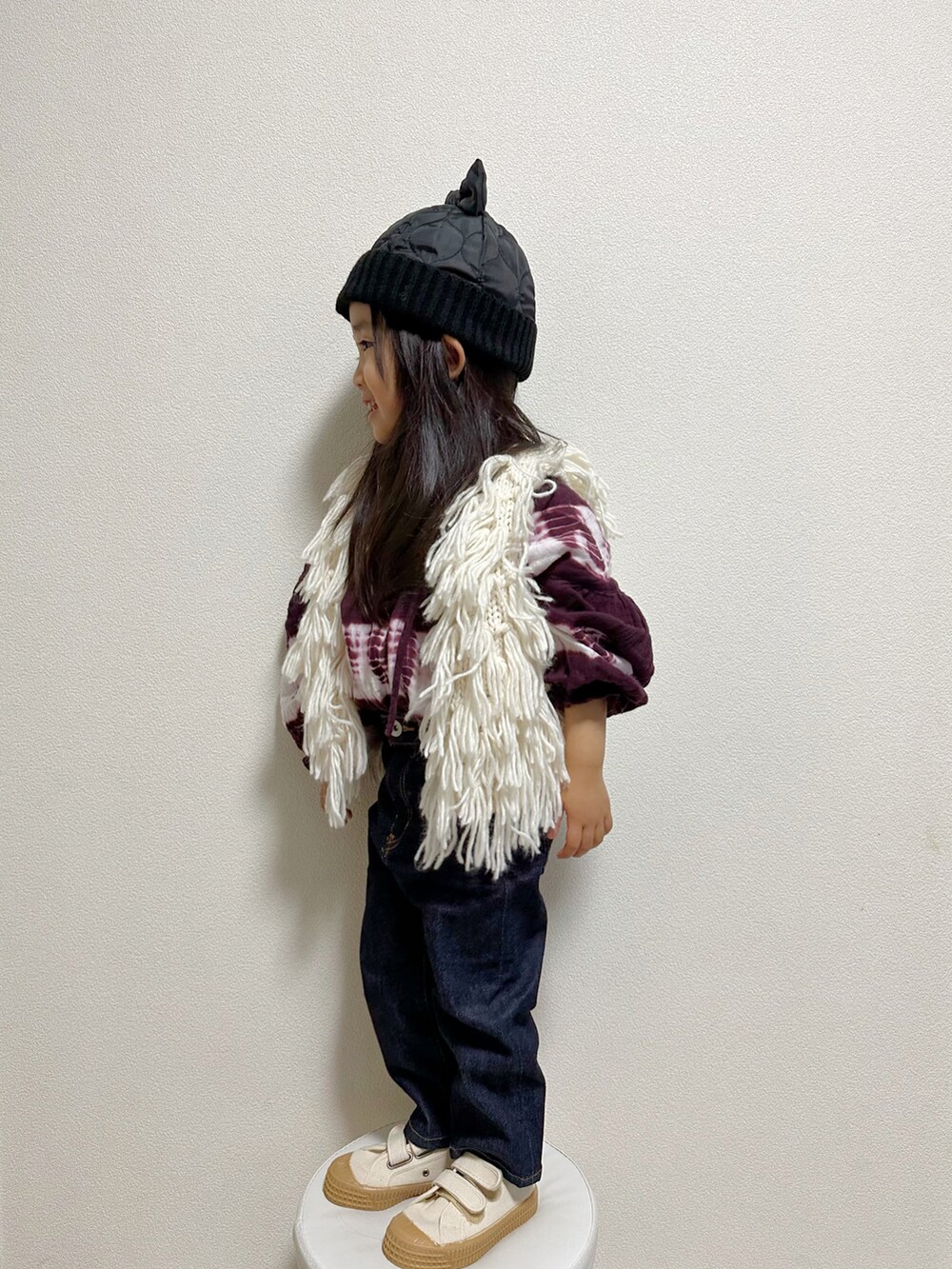 ホワイト系のその他アウター、レッド系のシャツ/ブラウス、ブルー系のデニムパンツを着用したキッズの冬コーディネートの3枚目の写真