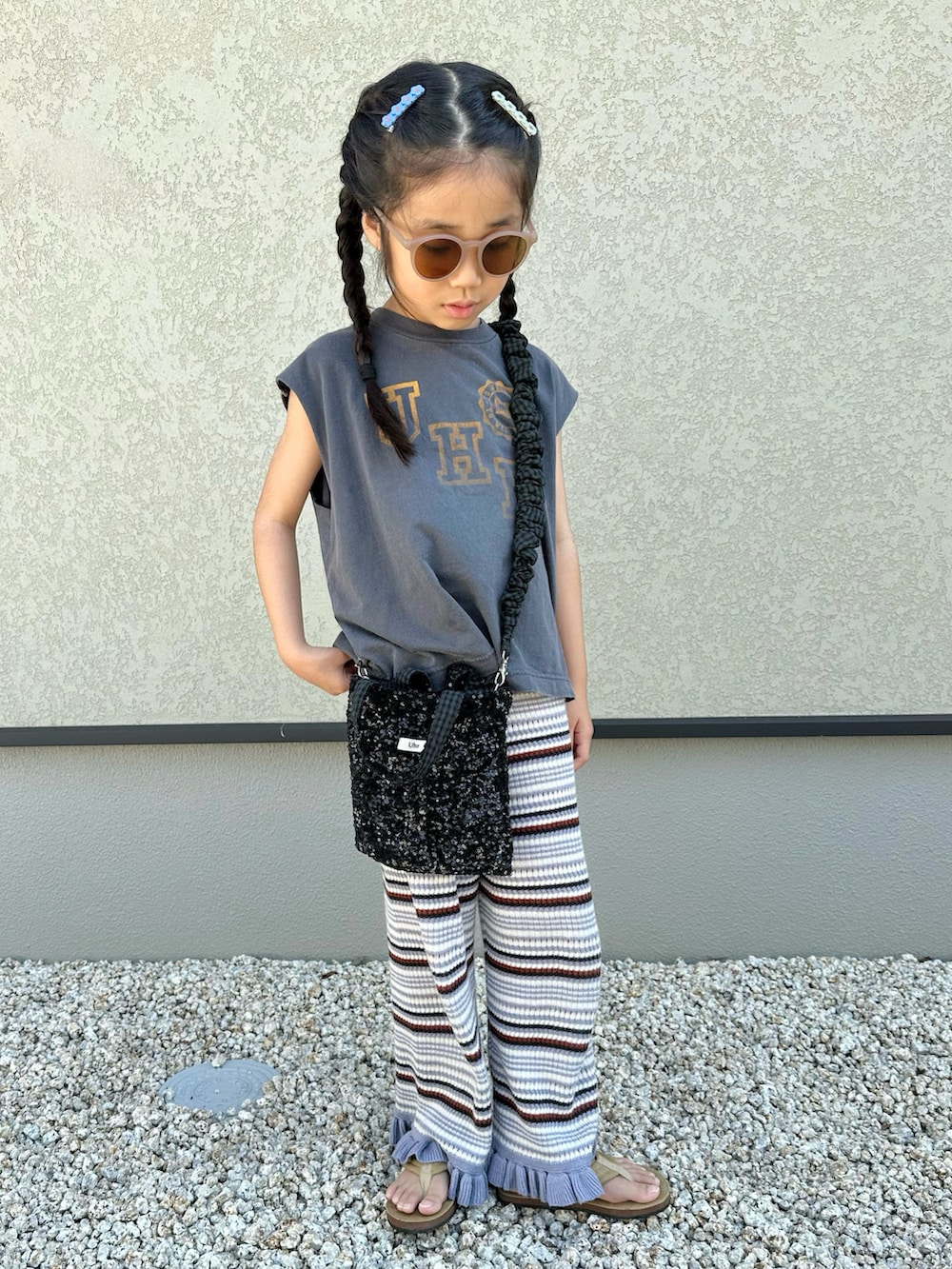 グレー系のTシャツ/カットソー、パープル系のパンツ、ブラック系のショルダーバッグを着用したキッズの夏コーディネートの2枚目の写真