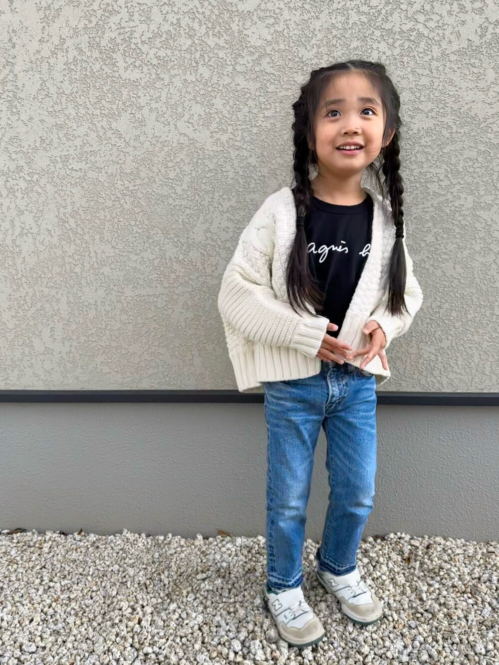 ホワイト系のカーディガン/ボレロ、ブラック系のTシャツ/カットソー、ブルー系のデニムパンツを着用したキッズの冬コーディネートの3枚目の写真