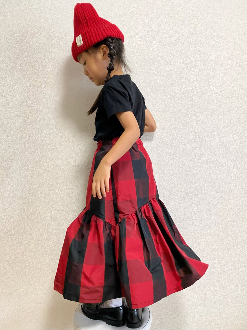ブラウン系のスタジャン、ブラック系のTシャツ/カットソー、レッド系のスカートを着用したキッズの秋コーディネートの5枚目の写真