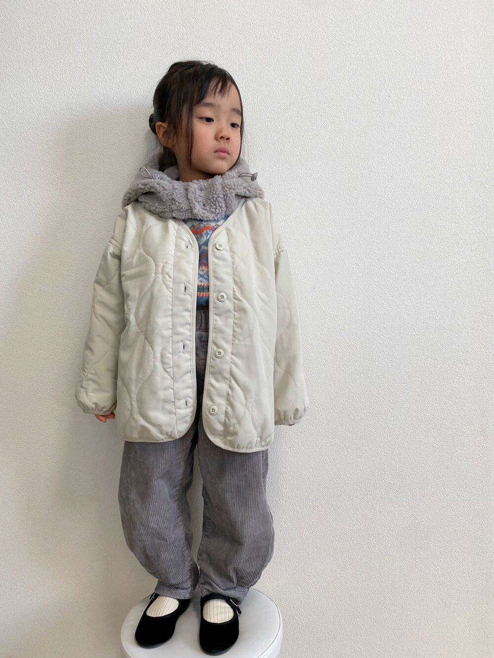 ホワイト系のマウンテンパーカー、ブルー系のニット/セーター、グレー系のパンツを着用したキッズの冬コーディネートの4枚目の写真