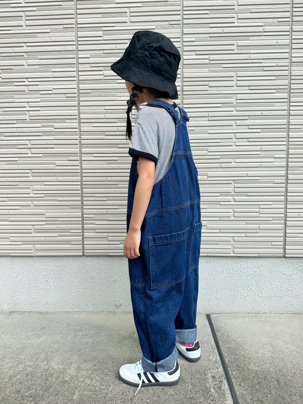 ブラック系のTシャツ/カットソー、ブルー系のサロペット/オーバーオール、ホワイト系のスニーカーを着用したキッズの秋コーディネートの4枚目の写真