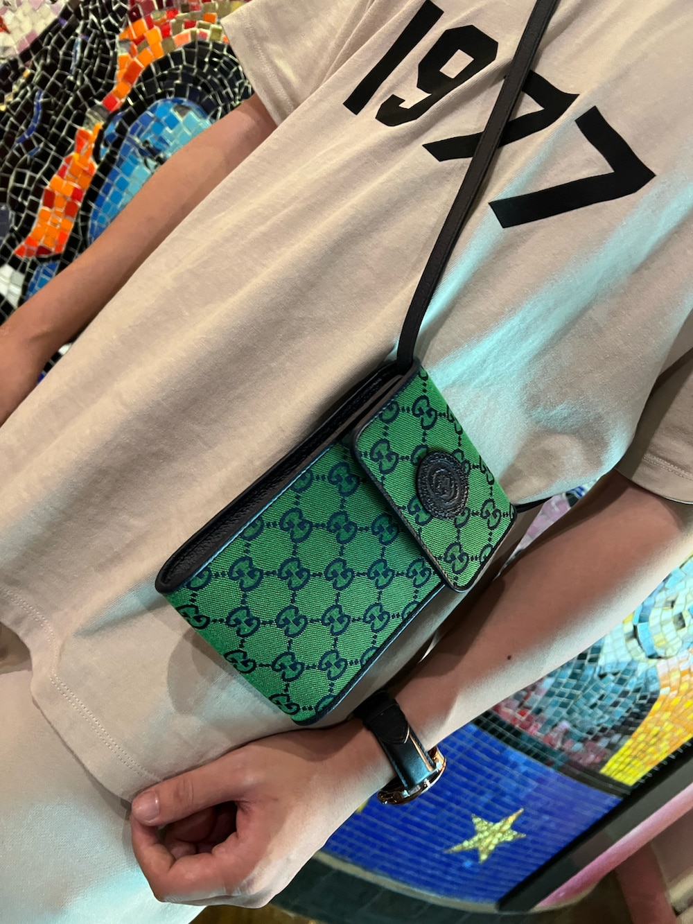 ベージュ系のTシャツ/カットソー、ベージュ系のパンツ、ブラック系のスニーカーを着用したメンズの夏コーディネートの2枚目の写真