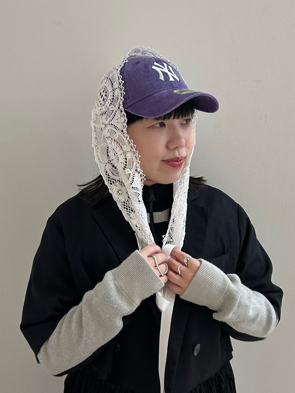 パープル系のキャップ、ホワイト系の付け襟を着用したレディースの春コーディネートの2枚目の写真