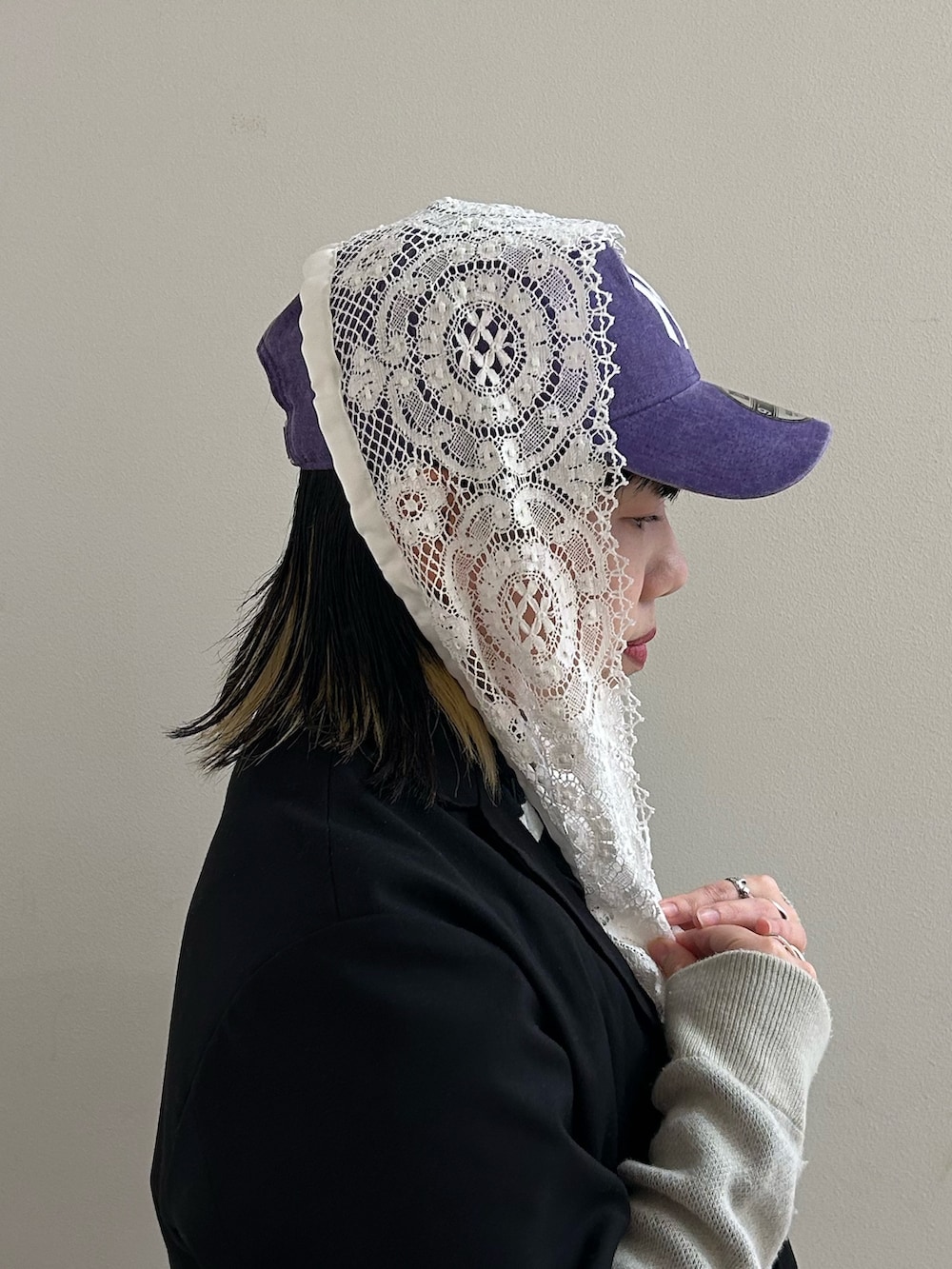 パープル系のキャップ、ホワイト系の付け襟を着用したレディースの春コーディネートの3枚目の写真