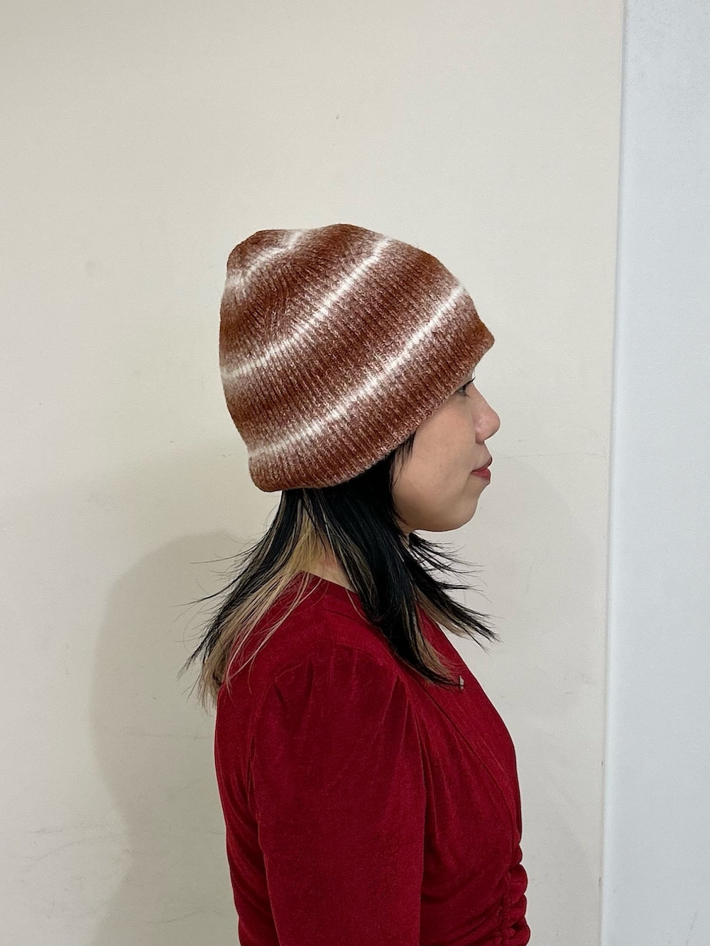 ブラウン系のニットキャップ/ビーニーを着用したレディースの秋コーディネートの3枚目の写真