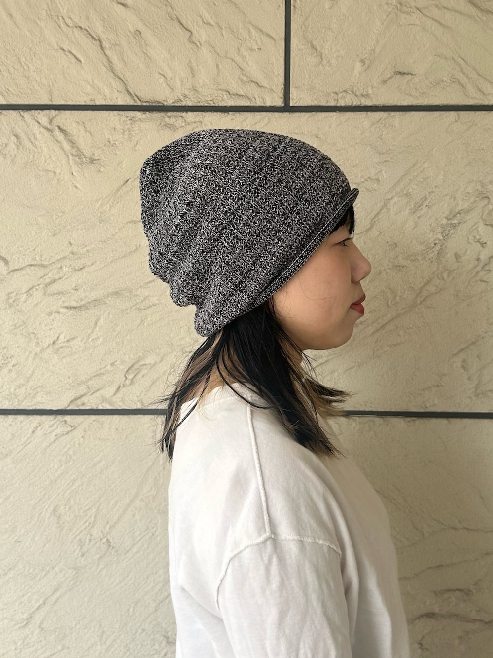 ブラック系のニットキャップ/ビーニーを着用したレディースの春コーディネートの3枚目の写真