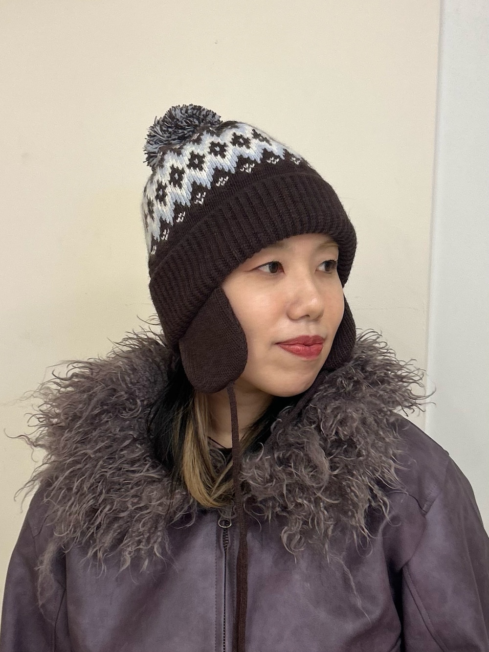 ブラウン系のニットキャップ/ビーニーを着用したレディースの秋コーディネートの2枚目の写真