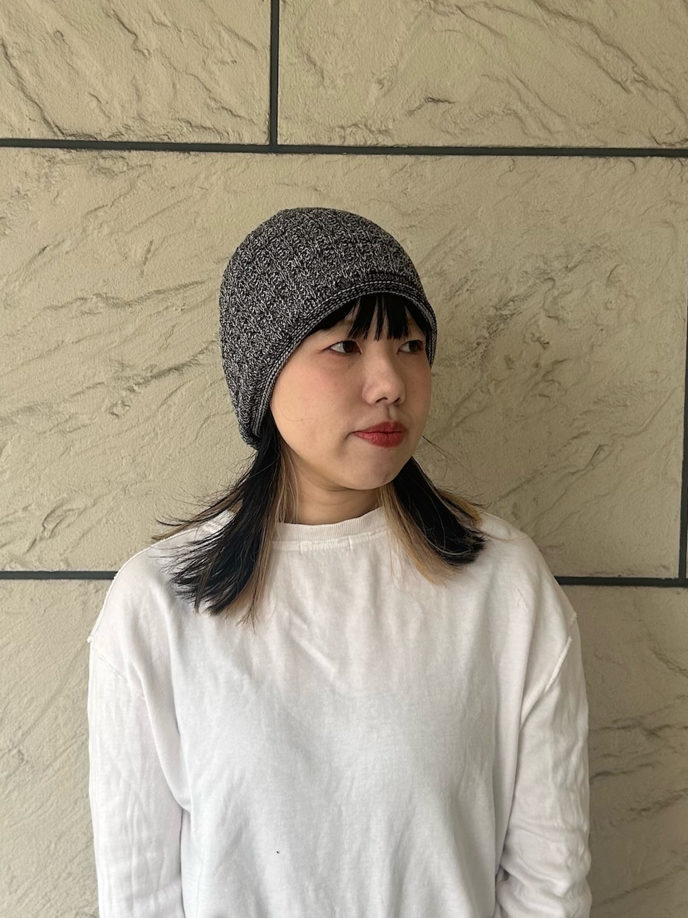 ブラック系のニットキャップ/ビーニーを着用したレディースの春コーディネートの2枚目の写真