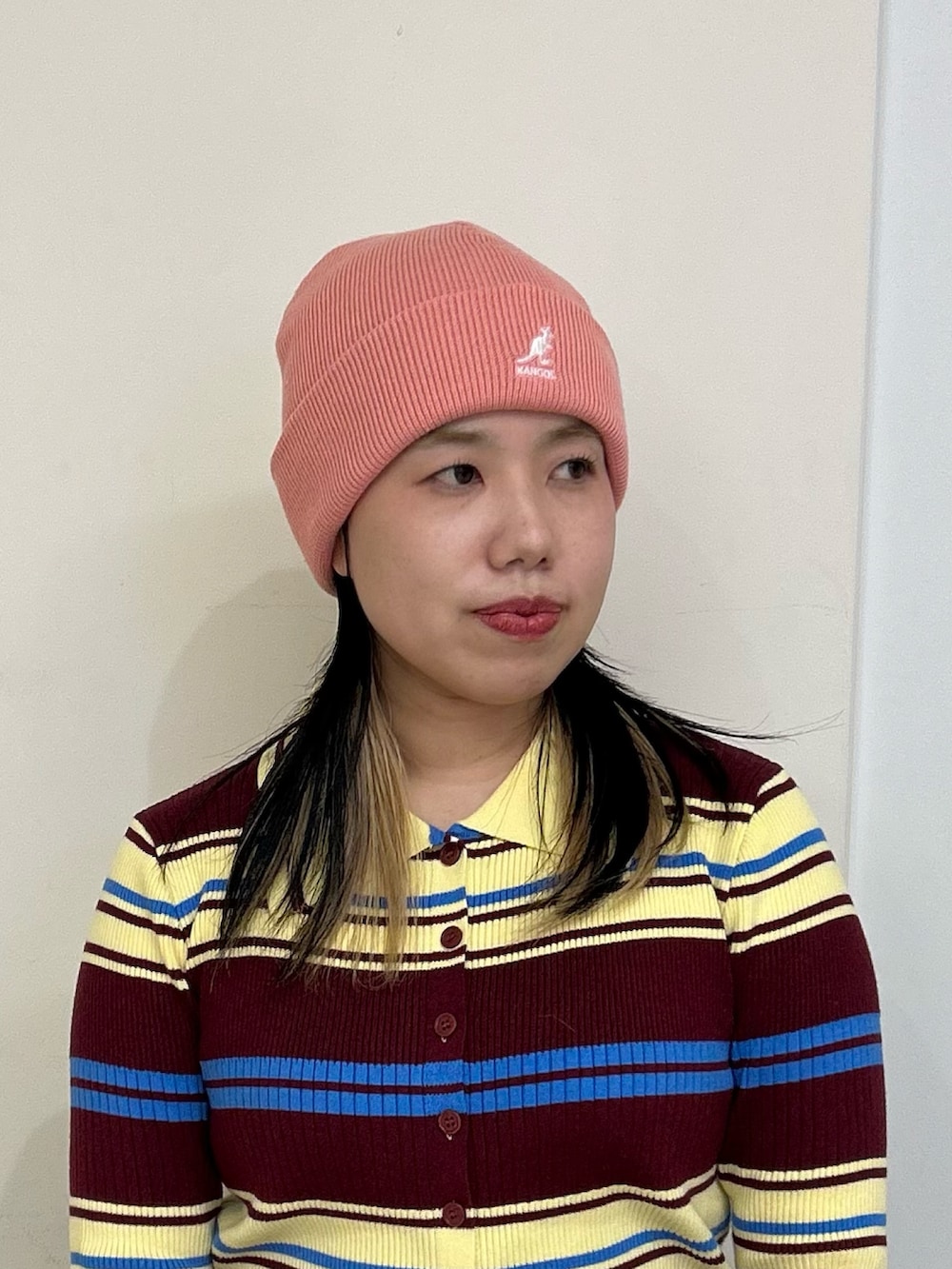 ピンク系のニットキャップ/ビーニーを着用したレディースの冬コーディネートの2枚目の写真