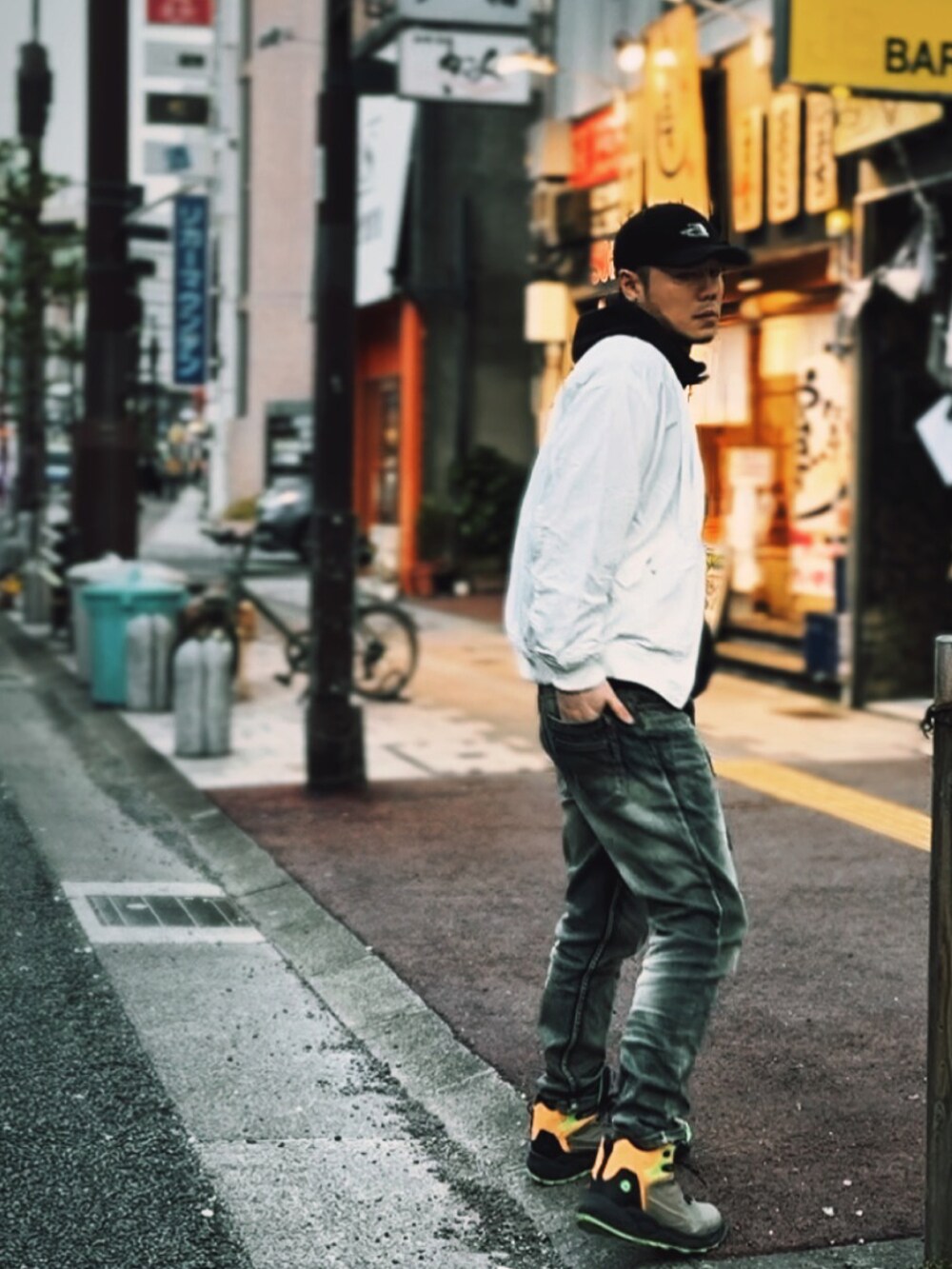 ホワイト系のMA-1、ブルー系のデニムパンツ、ブラック系のパーカーを着用したメンズの春コーディネートの3枚目の写真