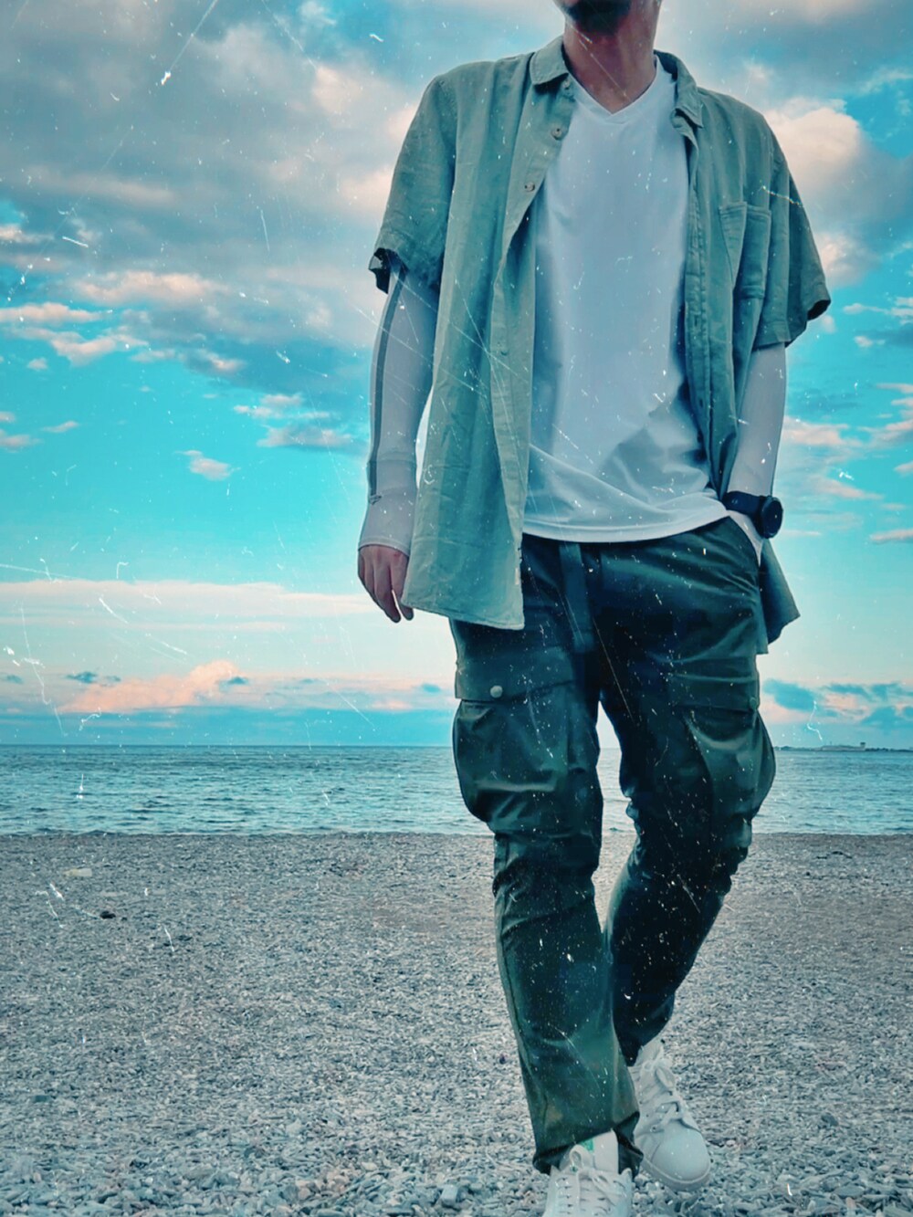 グリーン系のシャツ/ブラウス、グリーン系のカーゴパンツ、ホワイト系のスニーカーを着用したメンズの夏コーディネートの2枚目の写真