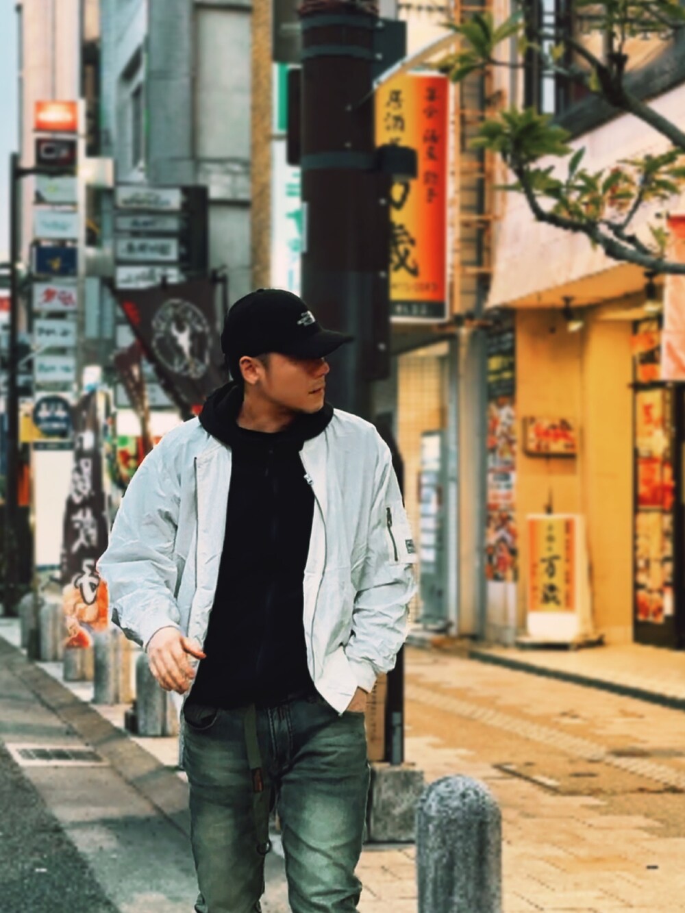 ホワイト系のMA-1、ブルー系のデニムパンツ、ブラック系のパーカーを着用したメンズの春コーディネートの2枚目の写真