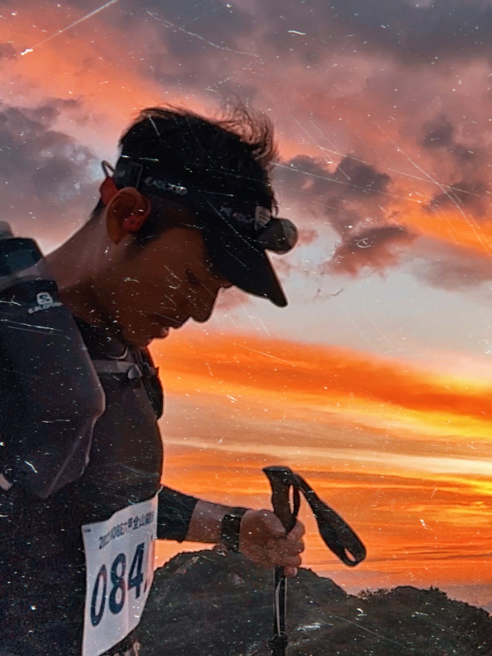 グレー系のトップス、グレー系のバックパック/リュック、ブラック系のアウトドアグッズを着用したメンズの秋コーディネートの2枚目の写真