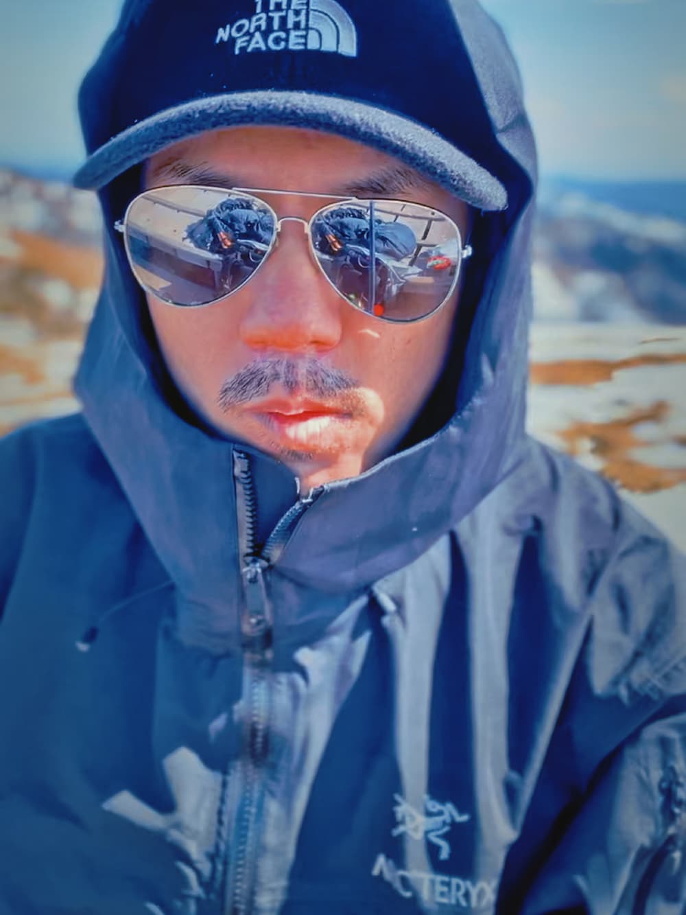 ブラック系のマウンテンパーカー、その他のその他パンツ、グリーン系のその他シューズを着用したメンズの春コーディネートの2枚目の写真