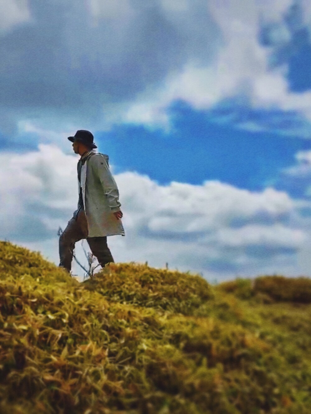 シルバー系のマウンテンパーカー、ベージュ系のカーゴパンツ、ブラック系のTシャツ/カットソーを着用したメンズの夏コーディネートの3枚目の写真