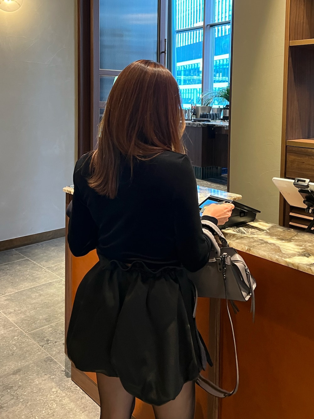 ブラック系のTシャツ/カットソー、ブラック系のブーツ、ブルー系のノーカラーコートを着用したレディースの秋コーディネートの2枚目の写真