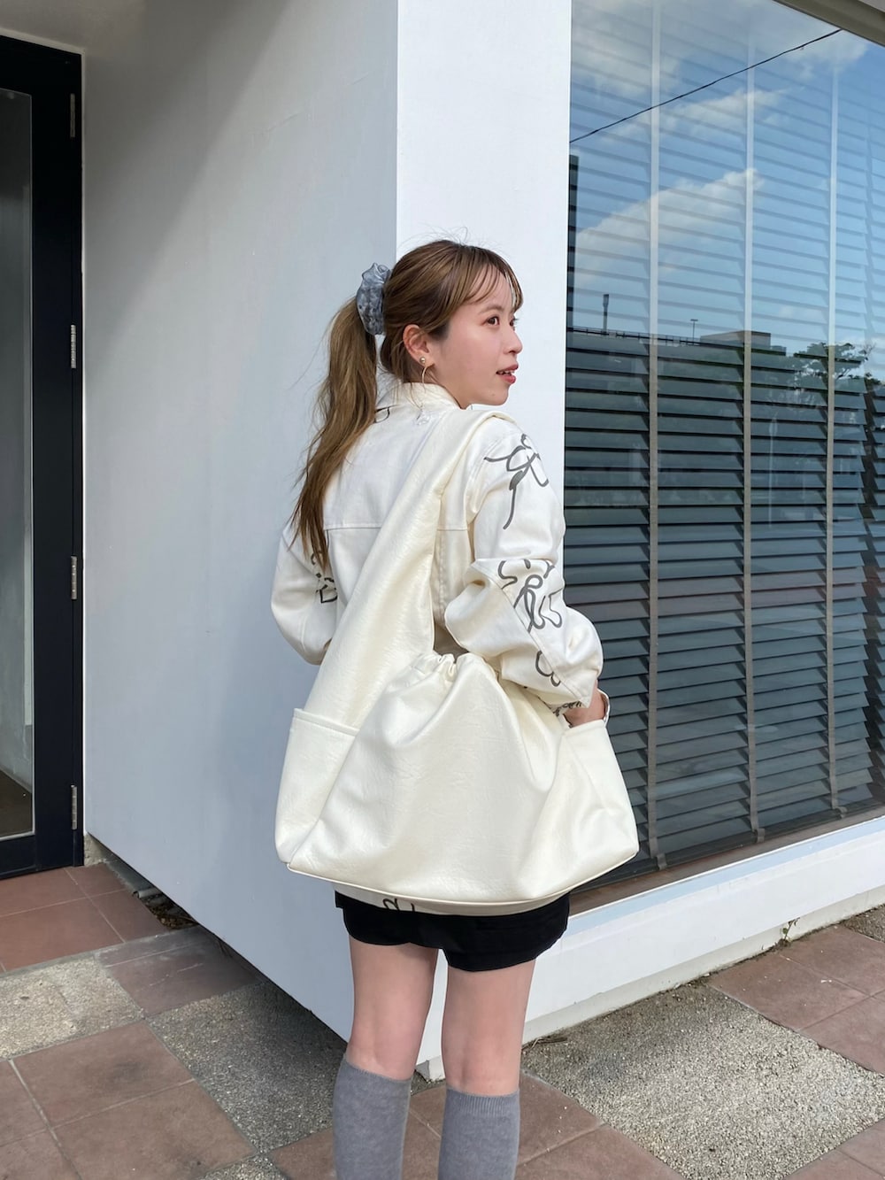 ブラック系のその他シューズ、ホワイト系のショルダーバッグ、グレー系のその他アウターを着用したレディースの春コーディネートの2枚目の写真