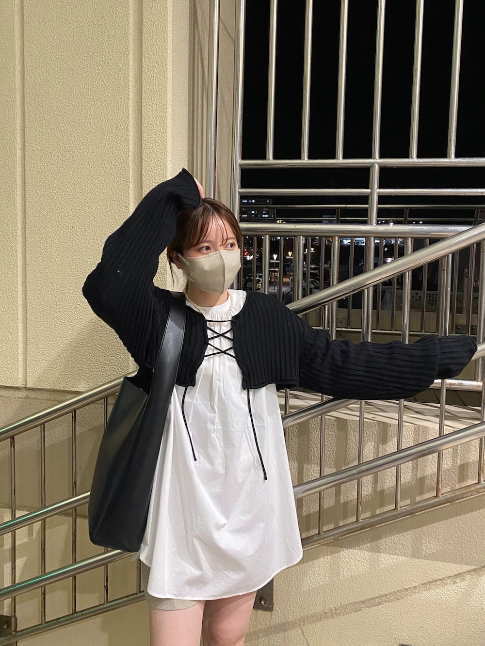 ブラック系のシャツ/ブラウス、ブラウン系のブーツ、ブラック系のトートバッグを着用したレディースの冬コーディネートの2枚目の写真