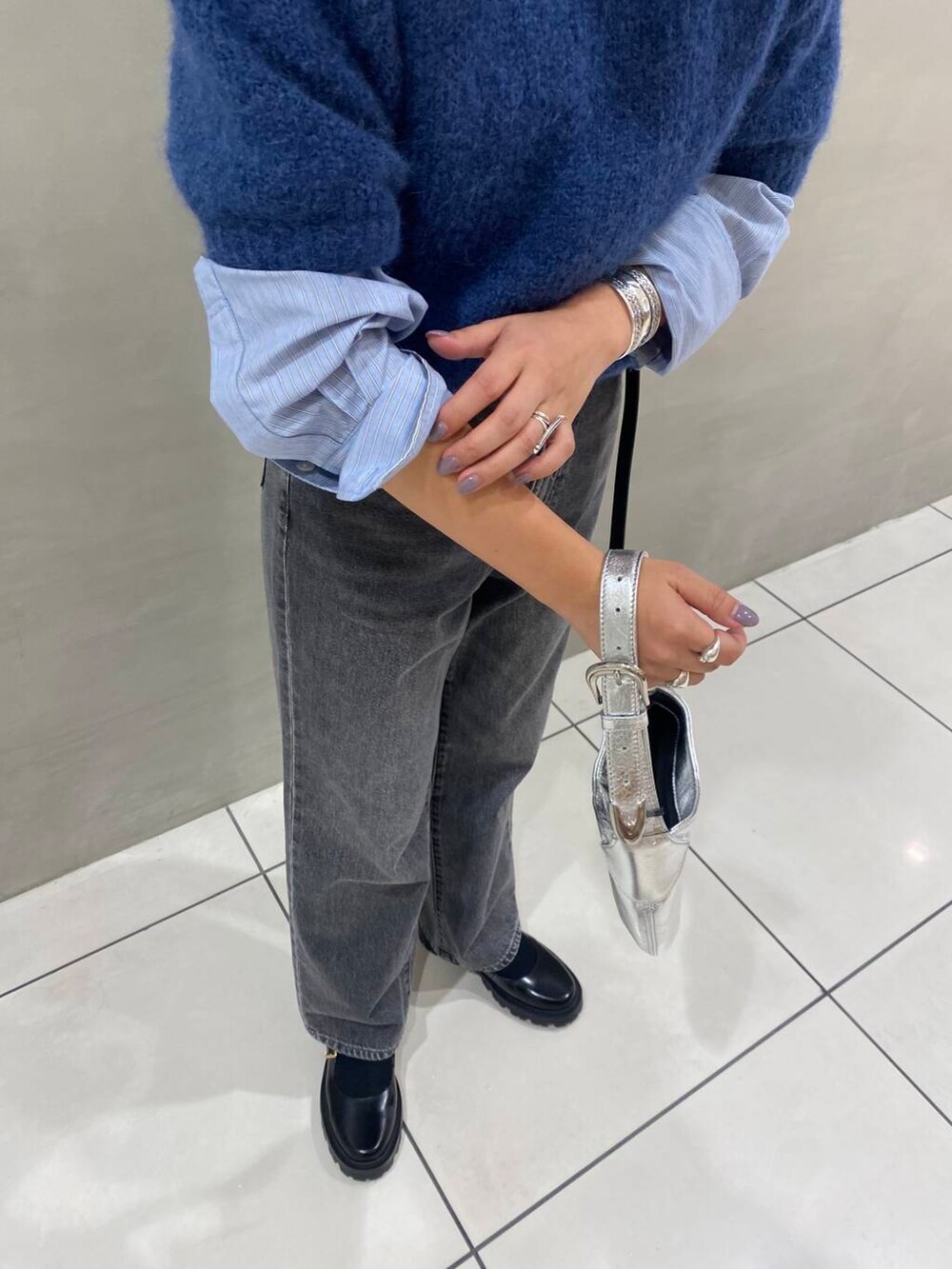 ブラック系のデニムパンツ、ブラック系のその他シューズ、ブルー系のTシャツ/カットソーを着用したレディースの秋コーディネートの4枚目の写真