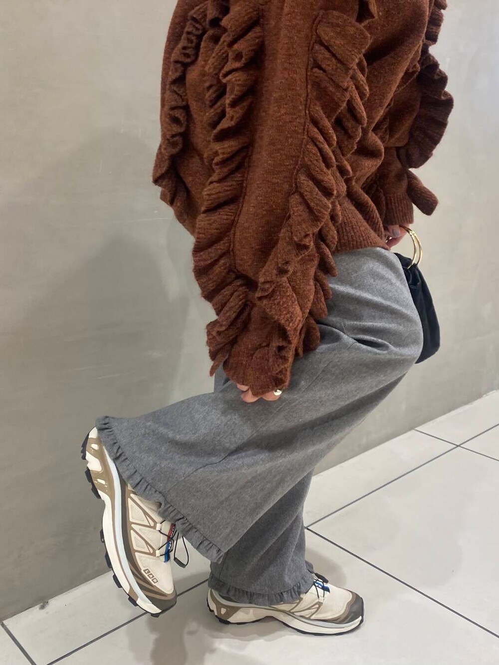 ブラック系のハンドバッグ、グレー系のその他パンツ、ブラウン系のニット/セーターを着用したレディースの秋コーディネートの4枚目の写真