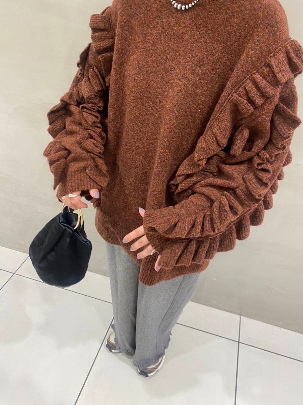 ブラック系のハンドバッグ、グレー系のその他パンツ、ブラウン系のニット/セーターを着用したレディースの秋コーディネートの3枚目の写真