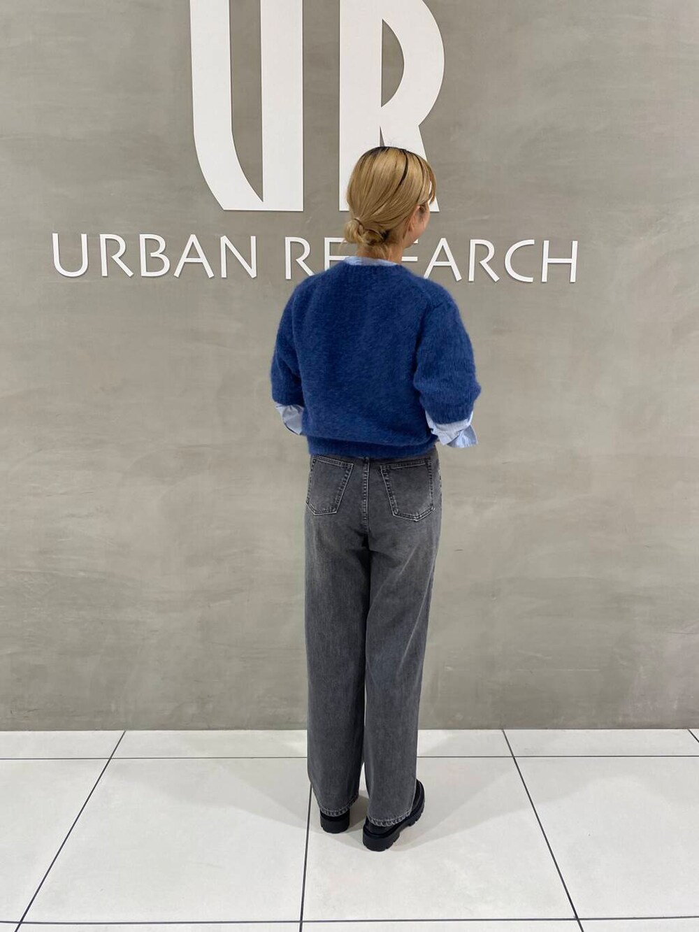 ブラック系のデニムパンツ、ブラック系のその他シューズ、ブルー系のTシャツ/カットソーを着用したレディースの秋コーディネートの2枚目の写真